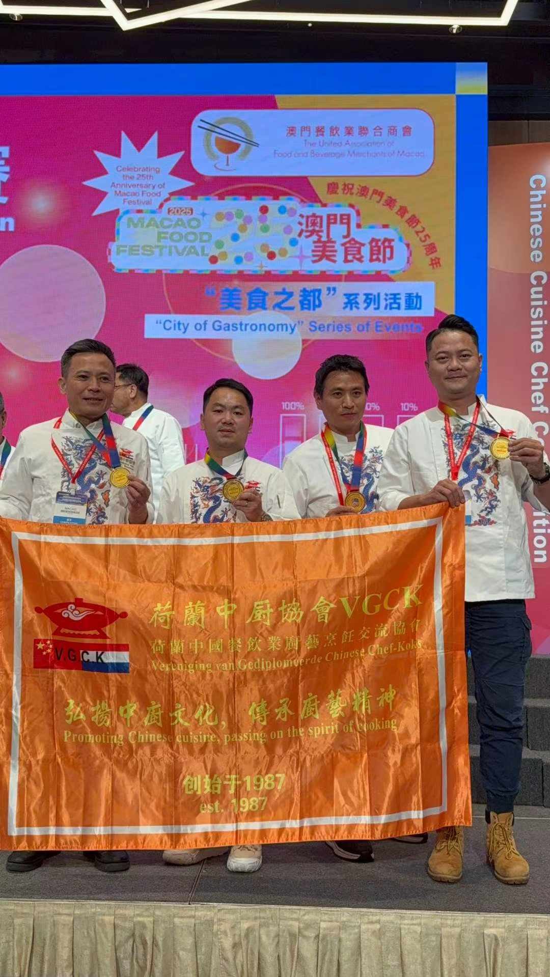 Het Nederlandse team met gouden medailles en de VGCK-vlag op het podium in Macau